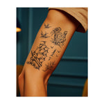 Ein Bündel klassischer Symbole: zwei fliegende Vögel, ein "GOOD LUCK" Hufeisen mit Blumen, ein Schiff, das auf Wellen segelt, und ein Dolch mit Blumen. Diese Designs fangen den abenteuerlichen Geist, Hoffnung und Schutz auf der Reise eines Seeleuten ein.