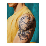 Ein dramatisches Tattoo mit einem Totenkopf und einer Uhr, bei dem die Zeit zu zerbrechen scheint. Es repräsentiert den unaufhaltbaren Fluss der Zeit und die Gewissheit des Todes. Ein kraftvolles, nachdenkliches Design für diejenigen, die über die Vergänglichkeit des Lebens nachdenken.