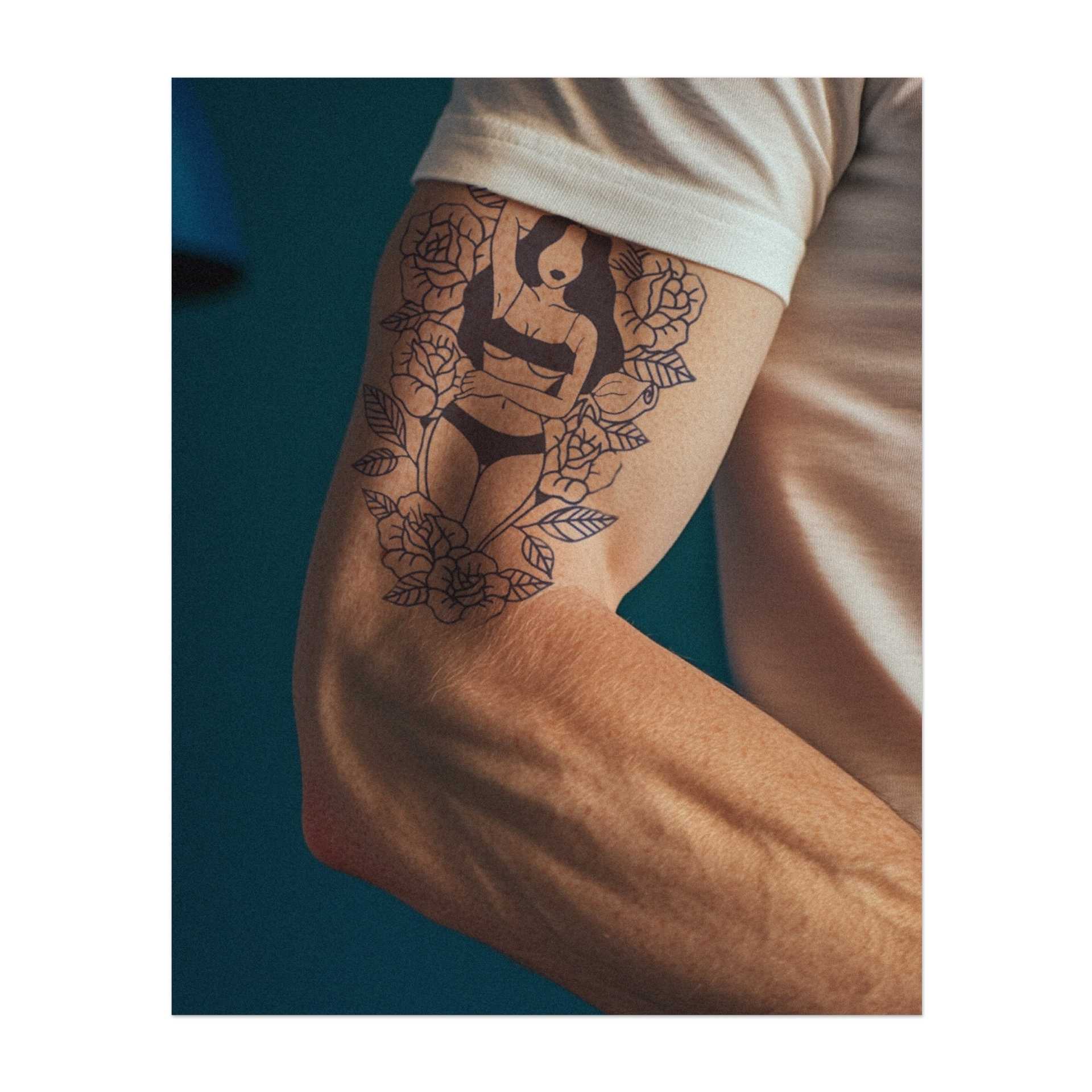 Eine anmutige Frau, umgeben von Rosen, die Schönheit und Selbstvertrauen verkörpert. Mit ihrer entspannten Haltung symbolisiert dieses Tattoo Weiblichkeit und Eleganz. Ein perfektes Design für jemanden, der seine innere Stärke schätzt und den zarten Charme der Natur liebt.