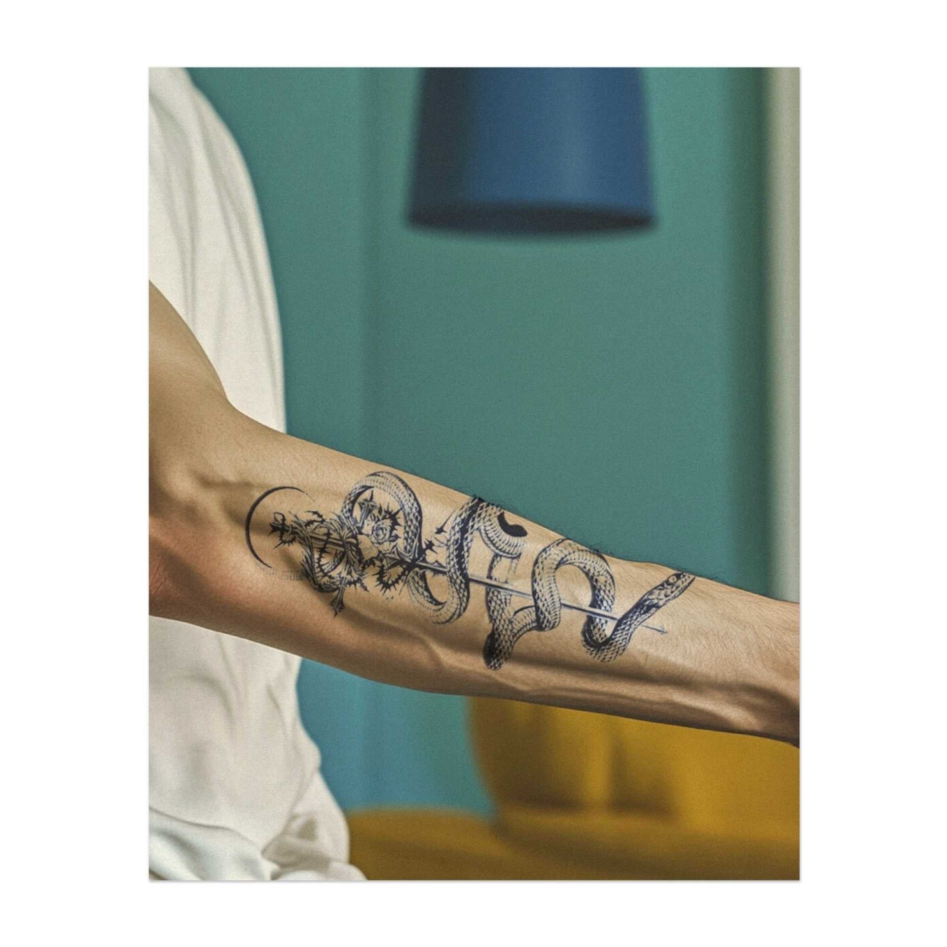 Eine anmutige Schlange, die sich um einen Stab windet, verflochten mit Blumen und oben gekrönt. Dieses Tattoo symbolisiert Heilung, Transformation und Weisheit und kombiniert alte Symbole mit natürlicher Schönheit. Perfekt für jemanden, der Balance und Wachstum in seiner Reise schätzt.