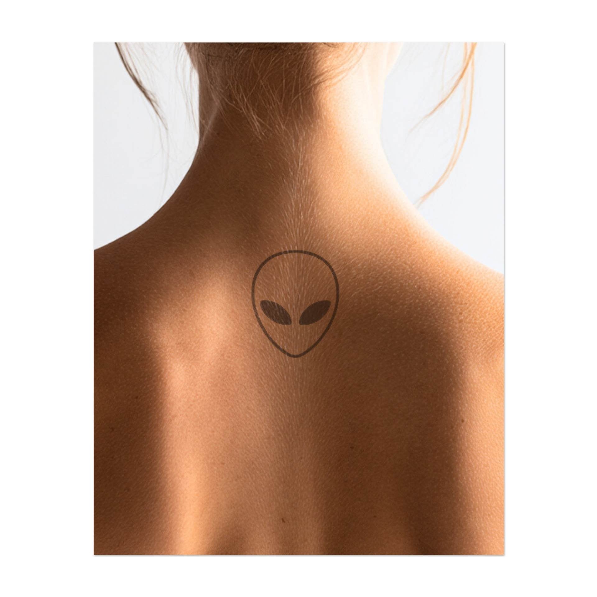 Un visage extraterrestre simple et mince avec de grands yeux mystérieux. Ce tatouage représente la curiosité, l'inconnu et l'énergie d'un autre monde, idéal pour ceux qui sont passionnés par l'univers et tout ce qui est mystérieux.
