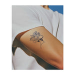 Un profil délicat d'une femme avec une couronne de fleurs et de feuilles vibrantes. Ce tatouage symbolise la beauté, la nature et la force intérieure. Parfait pour ceux qui apprécient la grâce, la croissance et le pouvoir de la beauté naturelle.
