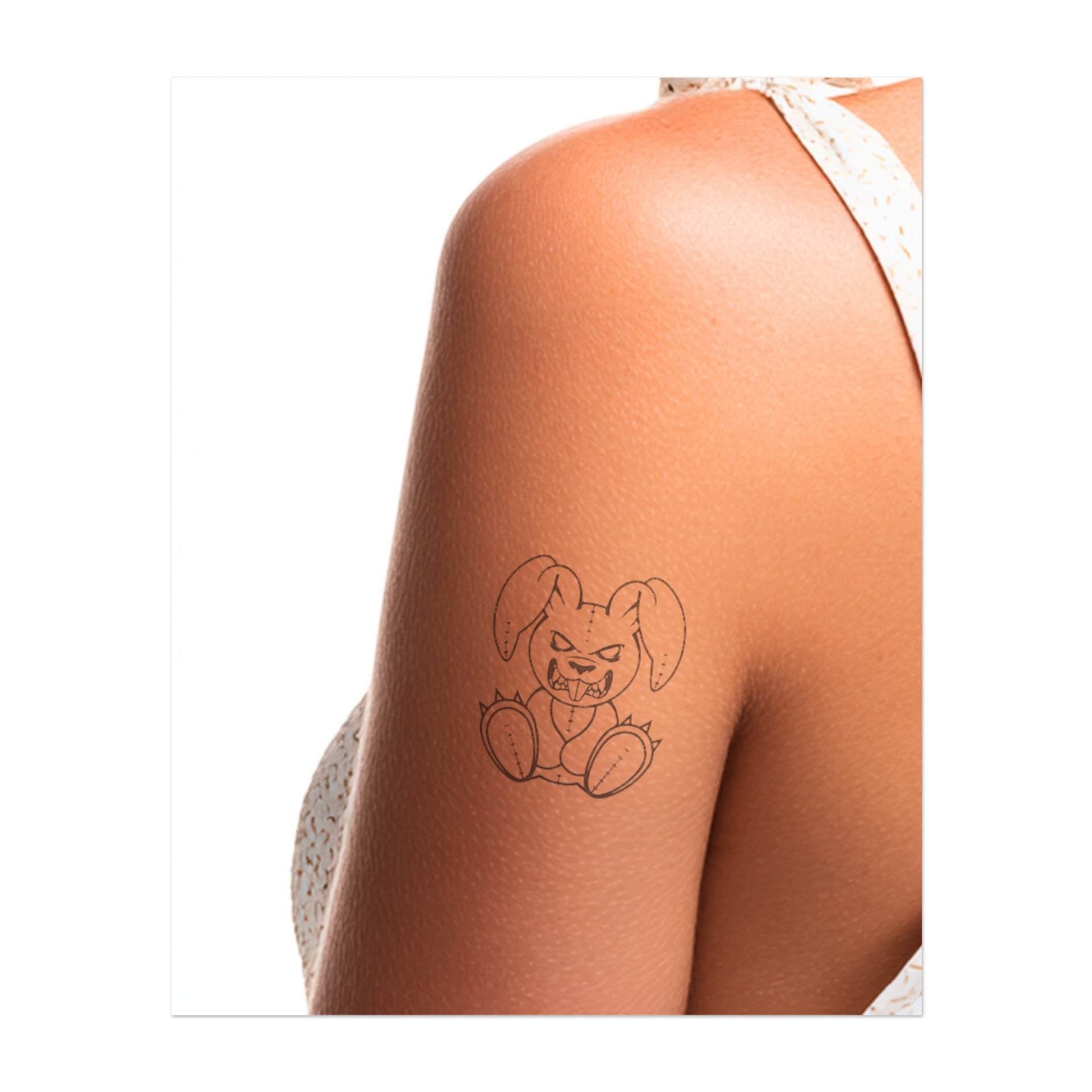Un lapin espiègle avec une expression grondante et des dents acérées. Ce tatouage représente la rébellion, l'attitude et une touche ludique, parfait pour ceux qui embrassent leur personnalité intrépide et audacieuse.