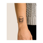 Un grand crâne avec un large sourire, symbolisant l'intrépidité et l'acceptation de la mortalité. Ce tatouage représente le côté le plus sombre de la vie, embrassant à la fois l'inévitable et la puissante force intérieure.