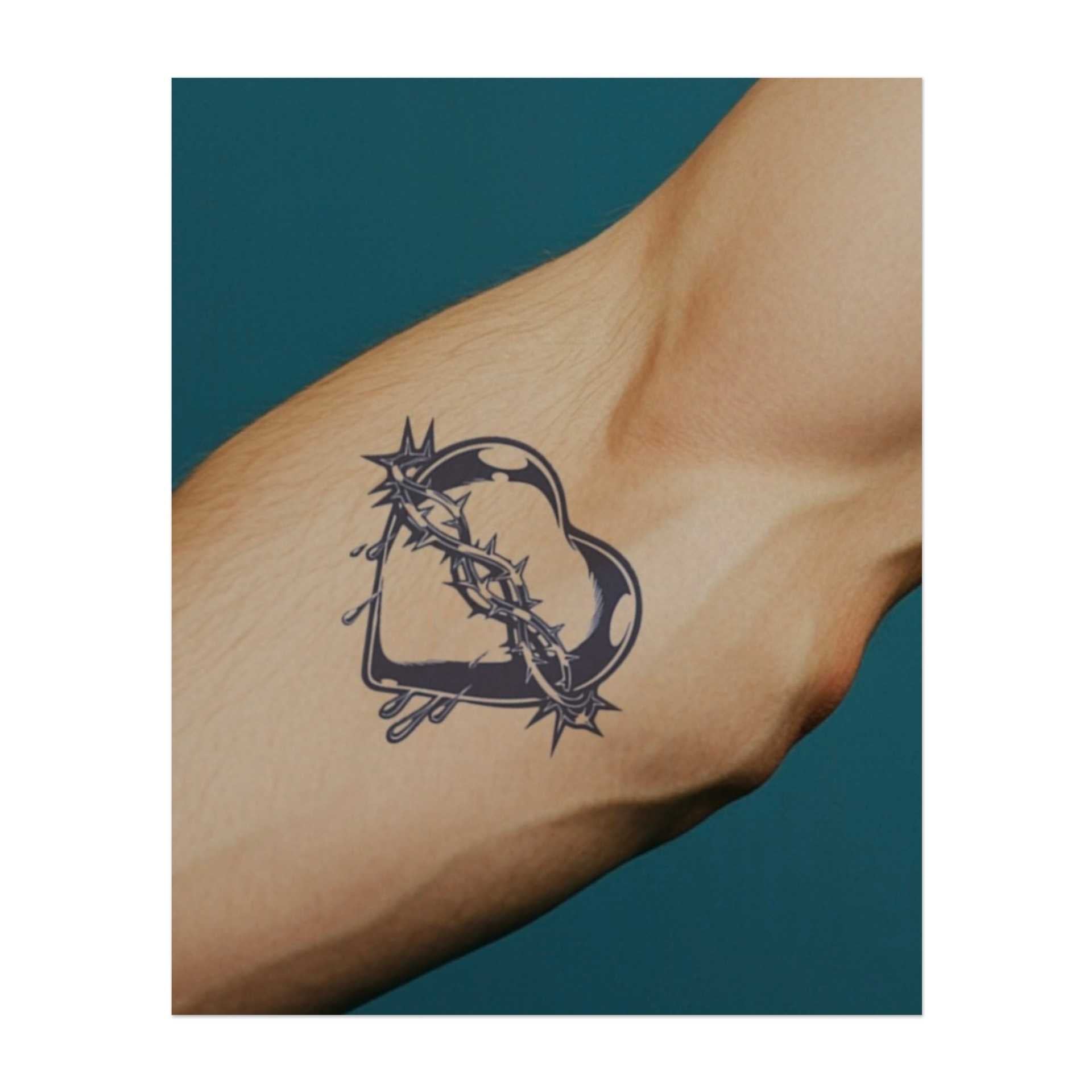 Un cœur enveloppé d'épines acérées, avec des larmes qui en coulent. Ce tatouage symbolise l'amour, la douleur et le sacrifice, représentant la complexité des émotions et la résilience nécessaire pour endurer le chagrin et la croissance.