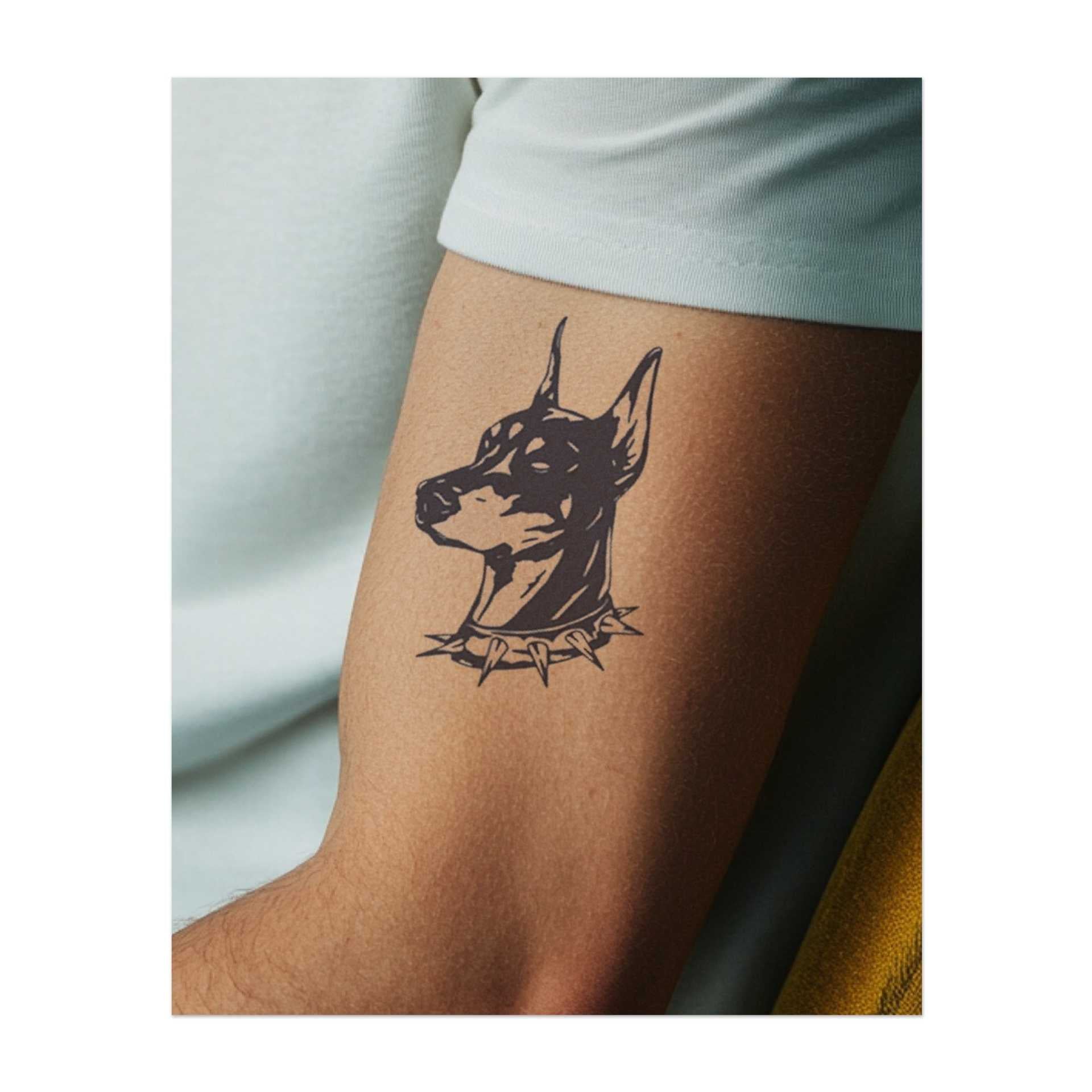 Ein Dobermann-Kopf mit einem stacheligen Halsband. Er symbolisiert Loyalität, Schutz oder Stärke.