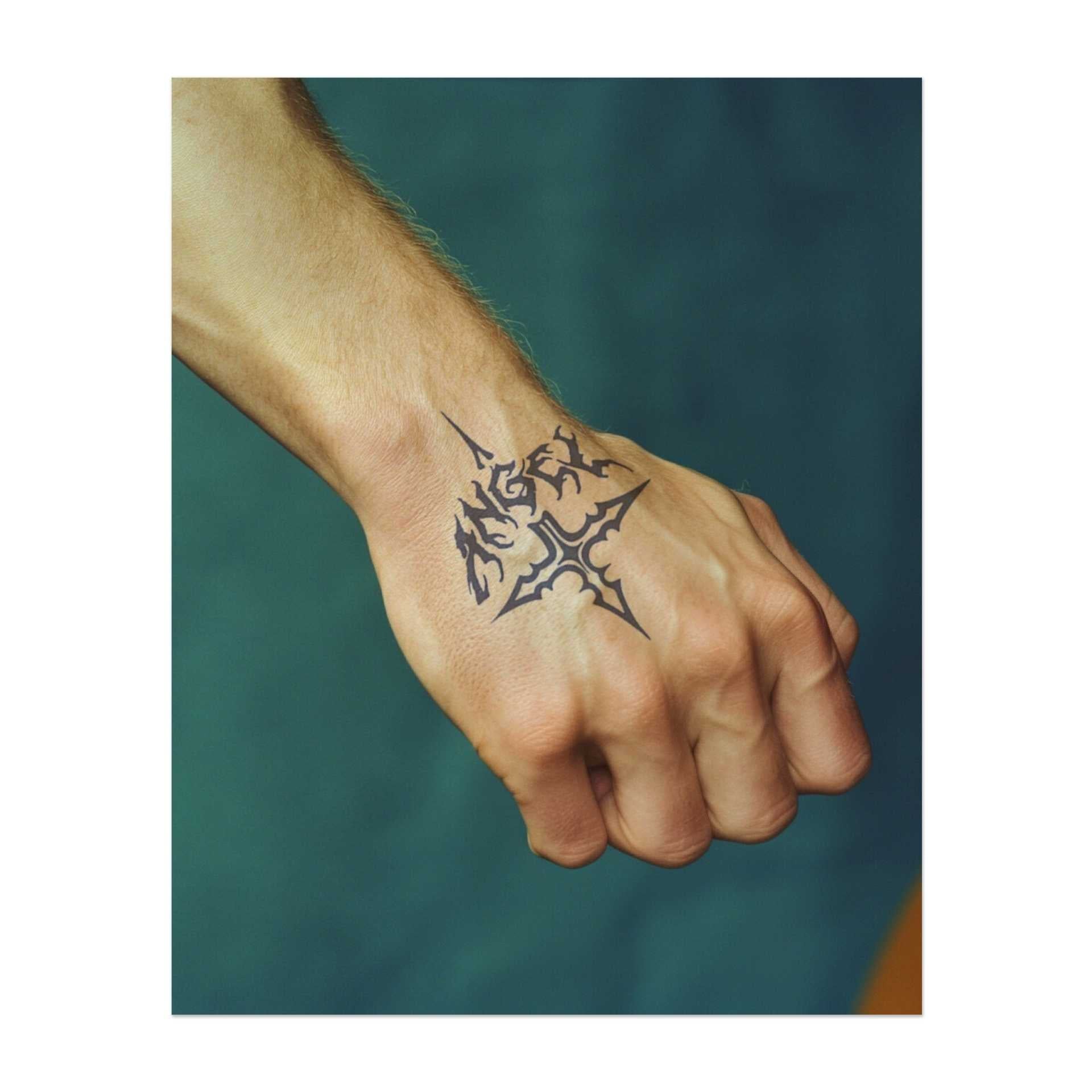 Das Wort "Angel" in gotischer Schrift, integriert mit einem dekorativen Kreuz. Es repräsentiert Glauben, eine dunklere oder kantige Sicht auf Spiritualität oder eine persönliche Verbindung zum Wort "Angel".